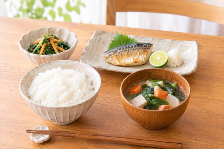 ごはん、具だくさんの味噌汁、焼き魚、和え物の一汁二菜の食卓